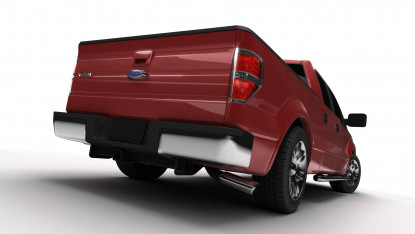 Red pickup truck viewed from the rear, showcasing sleek curves and shiny wheels. The bright lighting highlights the truck's robust and modern design.